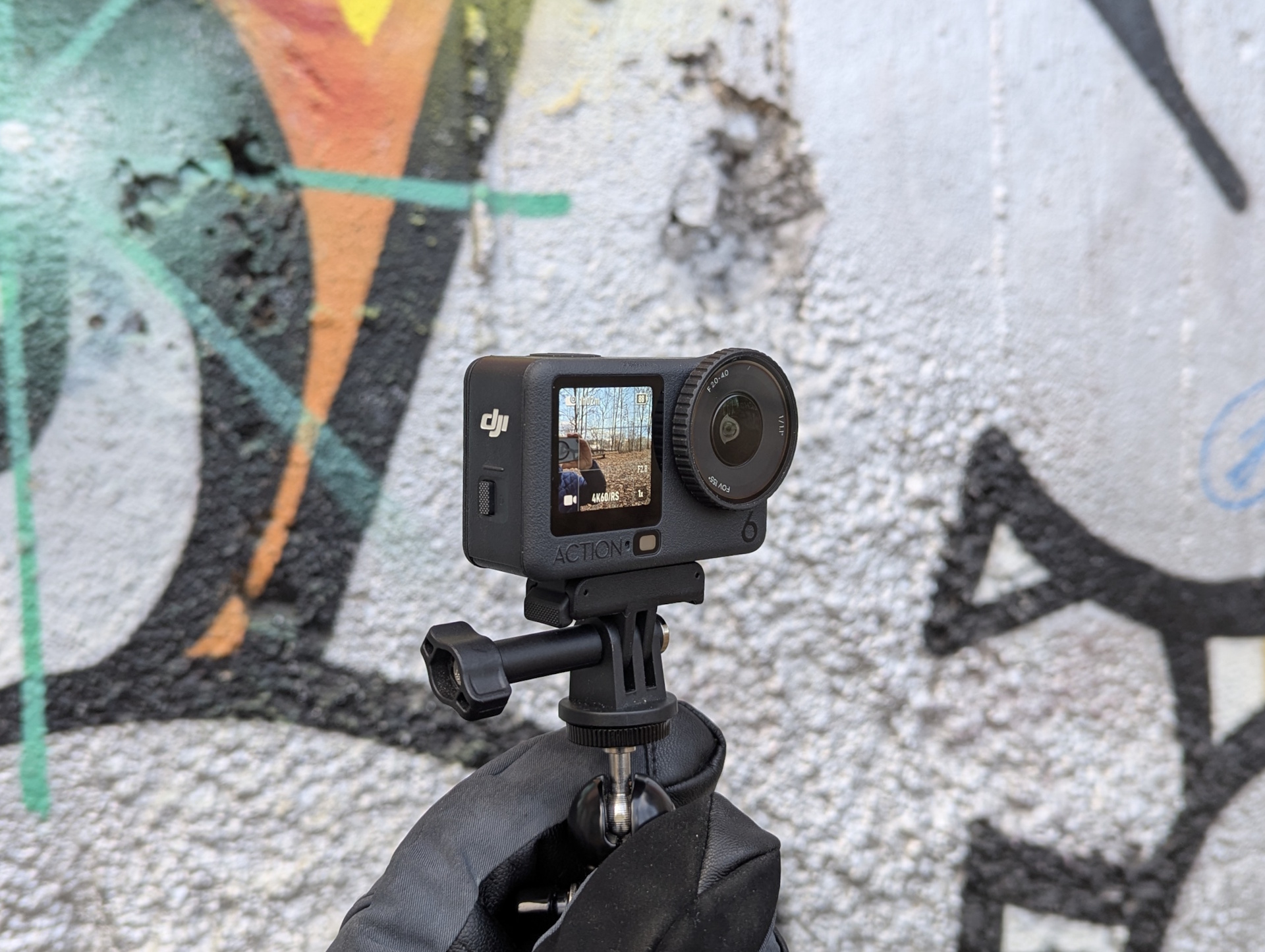 DJI Osmo Action 6 przed ścianą z graffiti