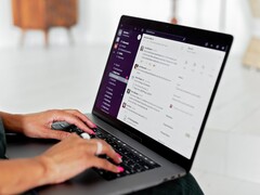 Dłonie piszące na klawiaturze laptopa z otwartą aplikacją do czatu