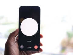 Dłoń trzymająca smartfon z interfejsem asystenta głosowego na ekranie