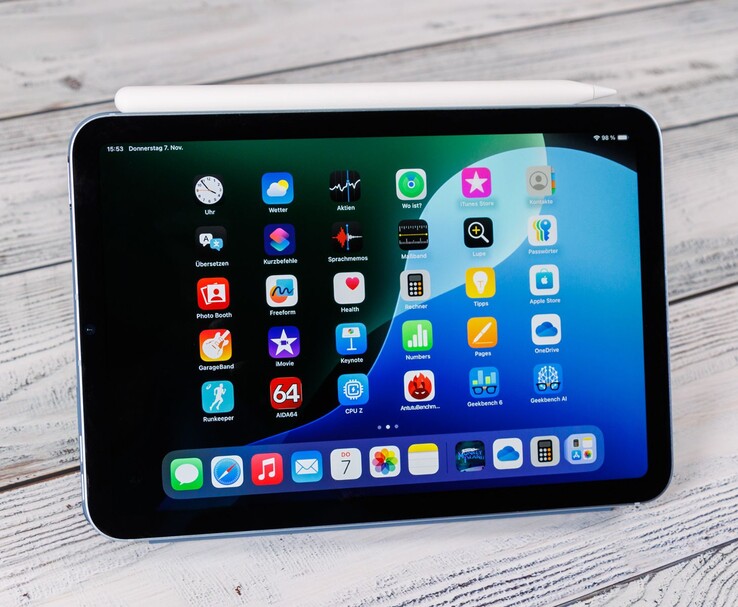 Widok z przodu iPada mini z ołówkiem Apple Pencil spoczywającym na górze, pokazującym ekran główny umieszczony na drewnianej powierzchni. (Źródło zdjęcia: Notebookcheck)