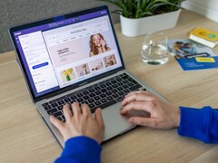 Ręce piszące na laptopie, na ekranie którego widoczny jest sklep internetowy.