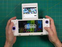 Russ z Retro Game Corps trzymający przenośną konsolę do gier OneXSugar Sugar 1 z dwoma ekranami, z grą Nintendo na głównym ekranie i filmem z YouTube odtwarzanym na dodatkowym wyświetlaczu. (Źródło obrazu: Retro Game Corps na YouTube)