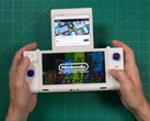 Russ z Retro Game Corps trzymający przenośną konsolę do gier OneXSugar Sugar 1 z dwoma ekranami, z grą Nintendo na głównym ekranie i filmem z YouTube odtwarzanym na dodatkowym wyświetlaczu. (Źródło obrazu: Retro Game Corps na YouTube)