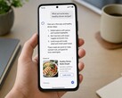 Dłoń trzymająca smartfon, na którym wyświetla się odpowiedź generowana przez sztuczną inteligencję, a poniżej znajduje się reklama sponsorowana