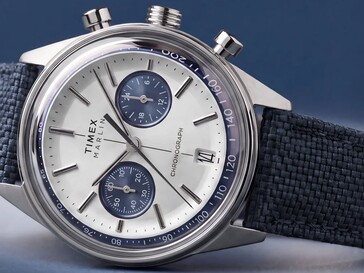 Chronograf Timex Marlin Jet sfotografowany na ciemnym tle, ukazujący wypukłą szybkę, pierścień tachymetryczny, wklęsłą tarczę, tarcze pomocnicze chronografu oraz retrofuturystyczny design koperty.