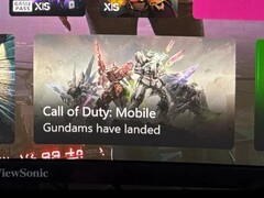 Zrzut ekranu pulpitu Xbox przedstawiający reklamę Call of Duty: Mobile z mechami Gundam i podpisem 