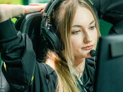Streamer noszący zestaw słuchawkowy do gier z mikrofonem na wysięgniku, siedzący przed ekranem podczas transmisji na żywo