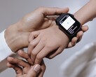 Ręka osoby dorosłej zakładająca smartwatch na nadgarstek dziecka