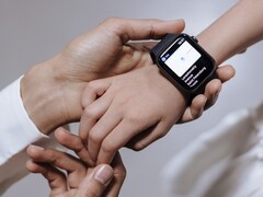 Ręka osoby dorosłej zakładająca smartwatch na nadgarstek dziecka