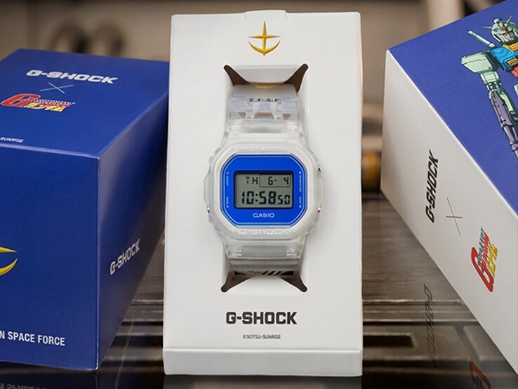 Casio G-Shock x Mobile Suit Gundam DW-5600 z przezroczystą kopertą i paskiem, niebieskim bezelem, brandingiem E.F.S.F. i kolekcjonerskim opakowaniem z grafiką Gundam.