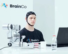 Użytkownik technologii sterowania umysłem firmy BrainCo, który za pomocą samych myśli w sposób automatyczny chwyta jabłko.