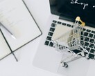 Miniaturowy koszyk na klawiaturze laptopa, z napisem „Kup teraz” na ekranie