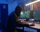 Haker generyczny przy stacji roboczej z dwoma monitorami przeprowadzający atak na łańcuch dostaw.