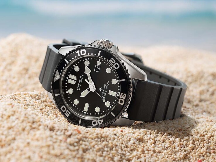Zegarek Citizen Promaster Marine BN0266-07E z czarną tarczą, czarną ramką i czarnym paskiem leżący na piasku.