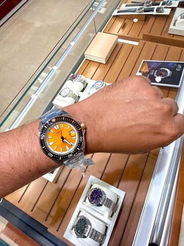 Zegarek nurkowy Seiko Prospex HBB005K1 inspirowany motywem tygrysa, noszony na nadgarstku, z bursztynową, teksturowaną tarczą, czarną ramką z pomarańczowymi akcentami oraz kopertą i bransoletą ze stali nierdzewnej.
