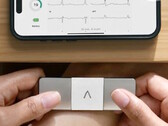 AliveCor KardiaMobile 6L Max trzymany obiema rękami w celu wykonania pomiaru EKG. (Źródło zdjęcia: AliveCor)