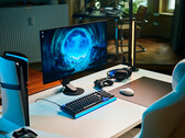 Przejrzysta konfiguracja do gier w studiu, w której na białym biurku znajduje się monitor Sony Inzone M10S II, a obok niego pionowo ustawiona konsola PlayStation 5 Pro, klawiatura mechaniczna, mysz bezprzewodowa oraz zestaw słuchawkowy z subtelnym niebieskim podświetleniem.