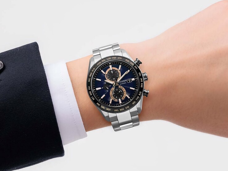 Chronograf Citizen Attesa AT8297-51L na nadgarstku, z granatową tarczą, akcentami w kolorze różowego złota i czarną lunetą czasu światowego.