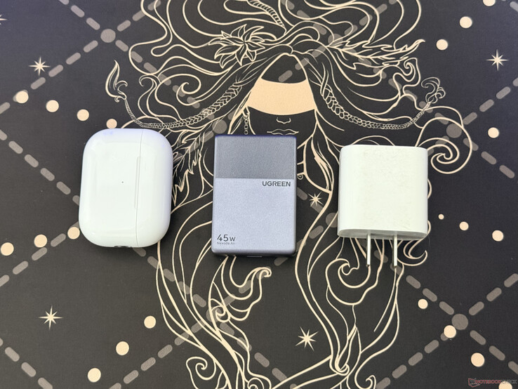 Urządzenie Ugreen Nexode Air 45 W Slim obok etui do słuchawek AirPods Pro oraz ładowac Apple a o mocy 18 W