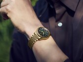 Zegarek Seiko Presage Classic x Tradman’s Bonsai noszony na nadgarstku, wyposażony w kopertę i bransoletę w złotym odcieniu oraz ciemnozieloną tarczę.