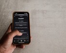 Dłoń trzymająca smartfon z interfejsem ChatGPT na ekranie nad szarą kamienną powierzchnią