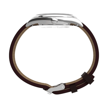 Widok z boku zegarka Timex Legacy Day and Date, eksponujący polerowaną kopertę ze stali nierdzewnej, żłobioną koronkę, zakrzywione uszy koperty i brązowy skórzany pasek na białym tle.