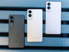 Trzy smartfony Samsung Galaxy Edge w kolorach czarnym, srebrnym i białym, umieszczone obok siebie na niebieskiej ławce, prezentujące ultrasmukłą tylną konstrukcję i konfigurację podwójnego aparatuTrzy smartfony Samsung Galaxy Edge w kolorach czarnym, srebrnym i białym, umieszczone obok siebie na niebieskiej ławce, prezentujące ultrasmukłą tylną konstrukcję i konfigurację podwójnego aparatu (źródło zdjęcia: Notebookcheck)