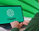Osoba pisząca na laptopie, na ekranie którego widoczne jest logo ChatGPT