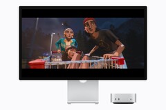 Zdjęcie przedstawia nowy komputer Mac mini M6 obok monitora Studio Display. Odtwarzany jest jakiś film.