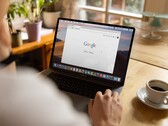 Osoba przy laptopie z otwartą stroną główną Google, obok filiżanki kawy