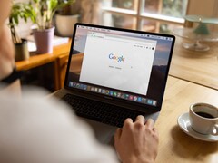 Osoba przy laptopie z otwartą stroną główną Google, obok filiżanki kawy