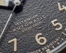 Zbliżenie na teksturowaną czarną tarczę zegarka Timex Expedition Field Post Titanium z cyframi arabskimi, świecącymi wskazówkami i znacznikami oraz okienkiem datownika.