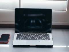 Proszę otworzyć laptopa i smartfon obok siebie na biurku w świetle dziennym