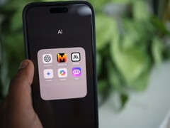 Dłoń trzymająca smartfon z folderem pełnym aplikacji AI na ekranie