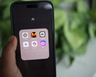 Dłoń trzymająca smartfon z folderem pełnym aplikacji AI na ekranie