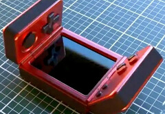 Nie jest jasne, kto stworzył ten dziwny handheld z klapką. (Źródło obrazu: via Nittrx)