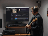 Gitarzysta gra przed monitorem wyświetlającym aplikację StemKit