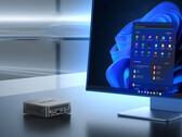NUC150 może być wyposażony w procesor Intel N150 lub Core 3 N355. Na zdjęciu: zdjęcie promocyjne mini PC siedzącego obok monitora. (Źródło zdjęcia: Minix)