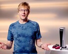  Mark Cerny podczas wydarzenia PlayStation, siedzący obok konsoli PS5 i kontrolerów DualSense. (Źródło obrazu: Sony Interactive Entertainment)