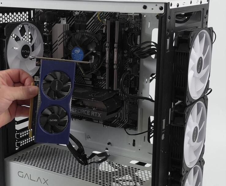 Ręka trzymająca kartę graficzną Intel Arc A380 obok komputera PC z kartą graficzną Nvidia GeForce RTX 3060, przygotowaną do konfiguracji z dwoma GPU i bezstratnym skalowaniem (źródło obrazu: ETA PRIME via YouTube)