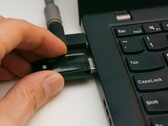 Osoba podłącza klucz bezpieczeństwa USB do laptopa