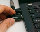 Osoba podłącza klucz bezpieczeństwa USB do laptopa