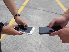 Dwie osoby trzymające dwa smartfony obok siebie podczas przekazania