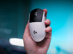 Mysz do gier Logitech G Pro X2 Superstrike w dłoni na niebieskim tle