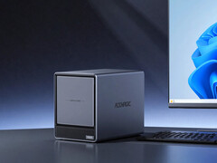 N3A posiada cztery kieszenie na dyski SATA i dwa gniazda na dyski SSD M.2. Na zdjęciu: zdjęcie promocyjne przedstawiające NAS umieszczony obok monitora.