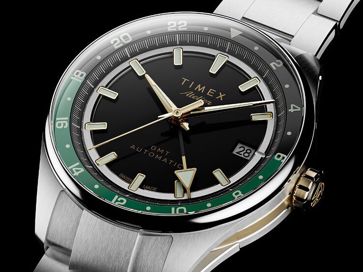 Widok pod kątem zegarka Timex Atelier GMT Première M1a, ukazujący jego czarną tarczę, zielony pierścień GMT, koronkę w złotym odcieniu i bransoletę ze stali nierdzewnej.