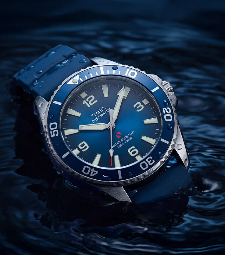 Timex Deepwater Arctic 200 z niebieską tarczą z efektem gradientu i pasującym niebieskim paskiem z gumy HNBR, sfotografowany częściowo zanurzony w wodzie.