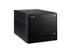 Zdjęcie przedstawia widok Shuttle XPC Mini PC, który wygląda jak czarny sześcian o minimalistycznym wyglądzie. 