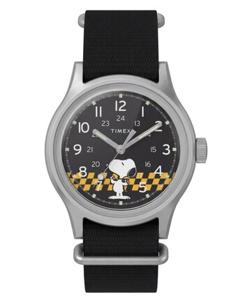 Widok z przodu zegarka Peanuts x Timex MK1 przedstawiający czarną tarczę, cyfry arabskie, świecące wskazówki i znaczniki oraz grafikę przedstawiającą Snoopy’ego w kratkę.
