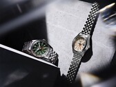 Modele Seiko 5 Sports Field GMT HDB001 z zieloną tarczą oraz HDB002 z kremową tarczą, prezentowane obok siebie na pięciogłowych bransoletkach ze stali nierdzewnej; każdy z nich wyposażony jest w nieruchomą 24-godzinną ramkę oraz pomarańczową wskazówkę GMT.